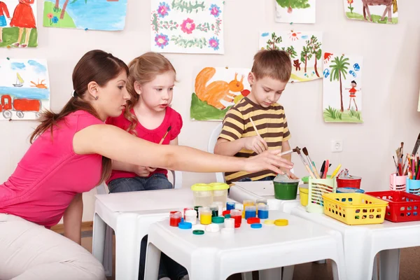 Kinder malen mit Lehrerin im Kunstunterricht. — Stockfoto