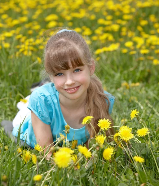 Lilla flickan liggande på gräs i blomma. — Stockfoto