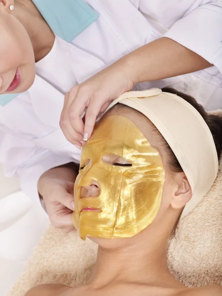 Meisje met gouden gezichtsmasker. — Stockfoto