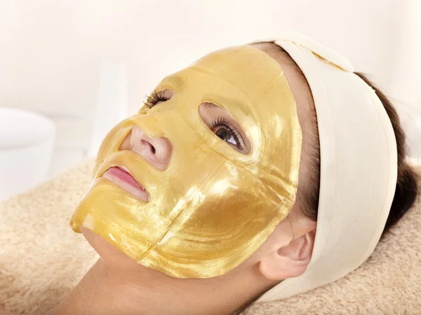 Meisje met gouden gezichtsmasker. — Stockfoto