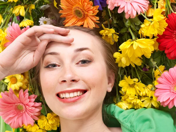 Νεαρή γυναίκα με λουλούδια που αγγίζετε το πρόσωπό. — Φωτογραφία Αρχείου