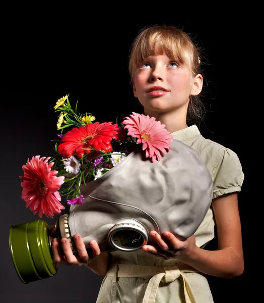 Barnet håller blommor och gasmask . — Stockfoto