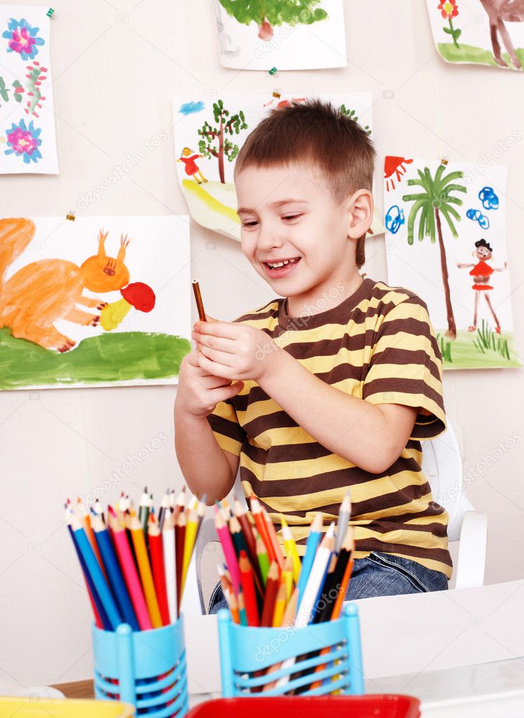 Child with pencil in play room.