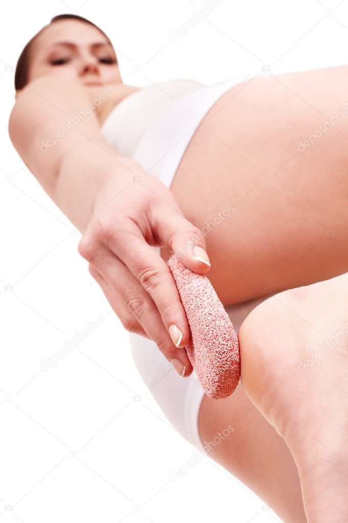 Woman rubbing heel of foot with pumice stone.