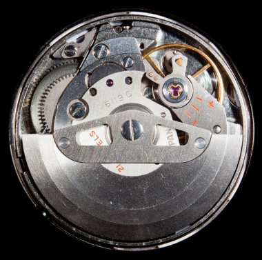 Macro image of the workings of an automatic wristwatch with cogs and polished stainless steel and ruby jewel clipart