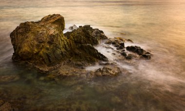 Long exposure sunset on sea rocks clipart