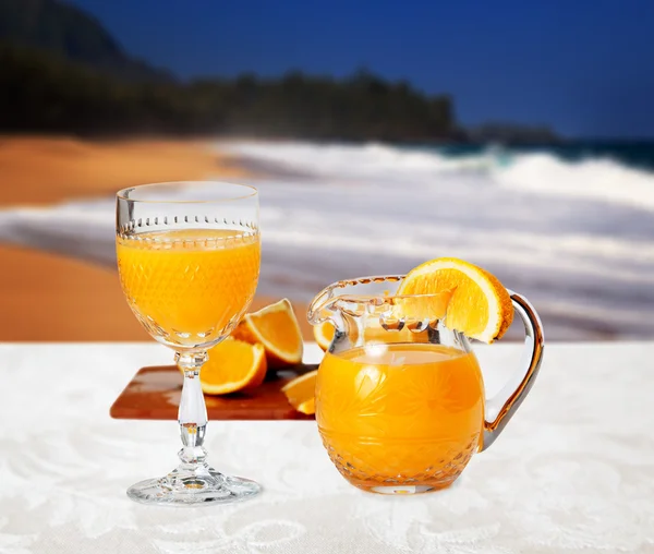 Verre d'orange sur la plage — Photo