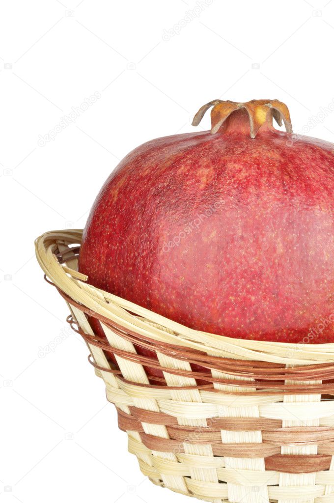 Ripe pomegranate in the basket isolated on a white background