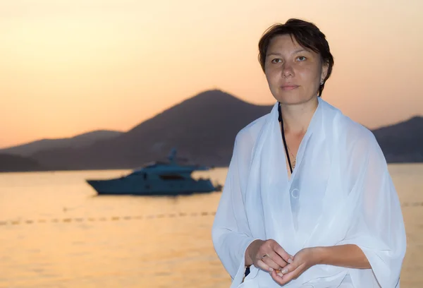 stock image Woman is standing alone on sea coast at sunset