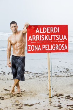 Sexy caucasian fit man posing in a beach clipart