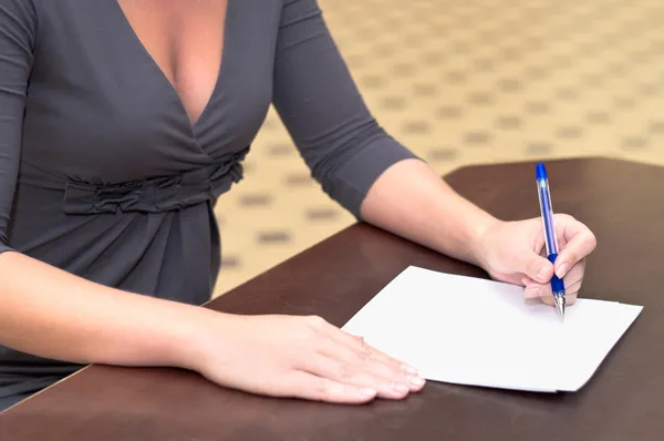 Mãos de mulher com uma caneta preenchendo o formulário — Fotografia de Stock