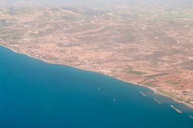 Kıbrıs sahil hattı mavi Akdeniz ve kahverengi topraklar ile bir uçağın üzerinden görüntülemek.