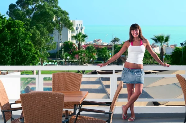 Unga vackra kvinnan stående på balkongen på hotellet — Stockfoto