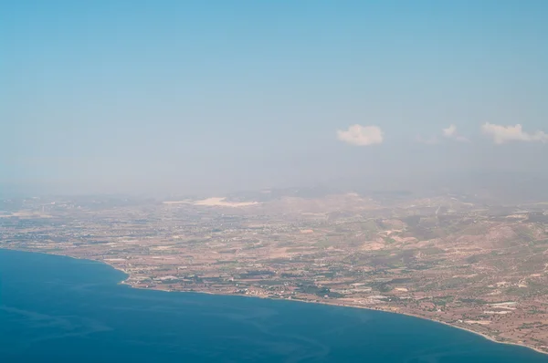 Uitzicht vanuit een vliegtuig van cyprus Zeekust lijn met blauwe Middellandse Zee en bruin land. — Stockfoto