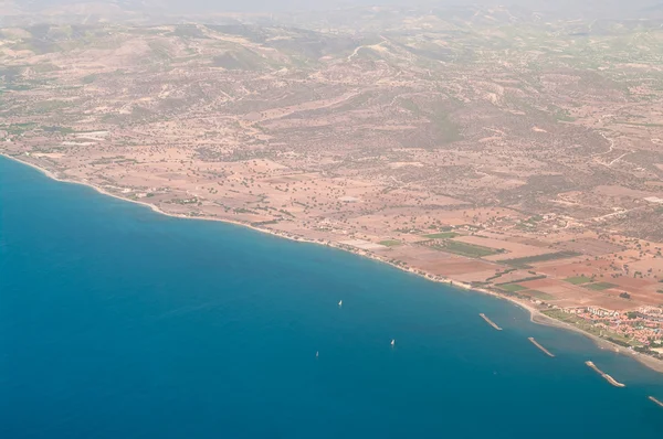Vue depuis un avion de la ligne côtière chypriote avec mer Méditerranée bleue et terre brune . — Photo