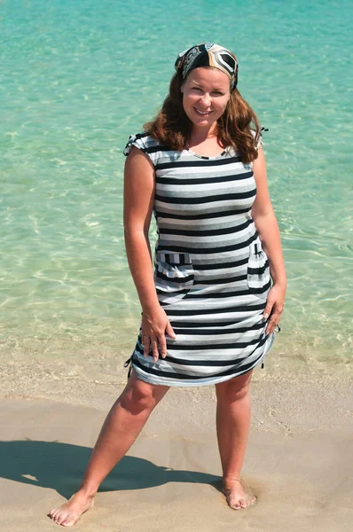 Menina bonita nova em uma praia de areia perto da costa mar azul — Fotografia de Stock