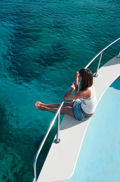 Женщина сидит на краю яхты — стоковое фото