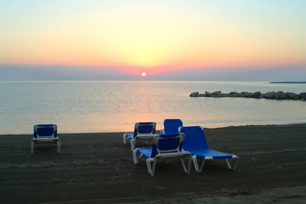 Nascer do sol no Mar Mediterrâneo e espreguiçadeiras de praia na areia. Bom dia. — Fotografia de Stock