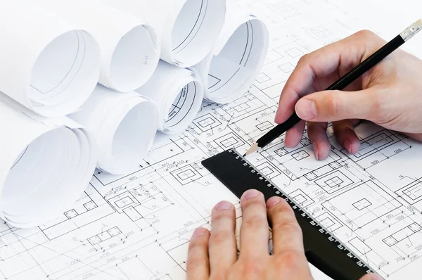Design drawings and human hands drawing a project — Stock Photo, Image