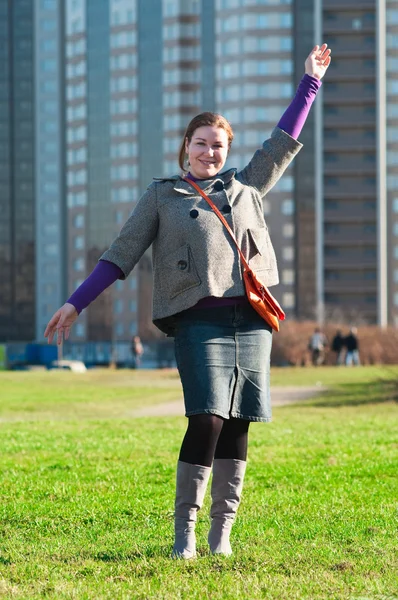 Happy beautiful woman standing in city park hands up — Stock Photo, Image