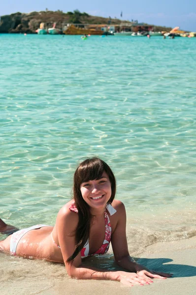 Молода красива дівчина лежить на піщаному пляжі біля берега — стокове фото