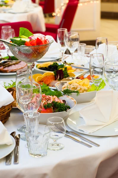 Тарелки с холодными закусками на столе, столовые приборы на ужин — стоковое фото