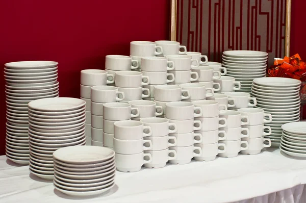 Λευκό φλιτζάνια τσάι που συσσωρεύονται στο τραπέζι με πλάκες για διάλειμμα για καφέ — Φωτογραφία Αρχείου