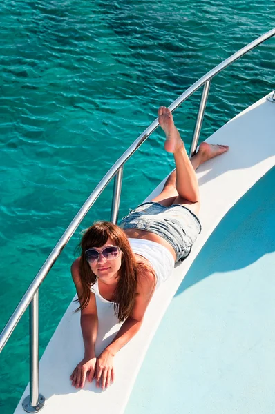 Молода красива дівчина лежить на яхті — стокове фото