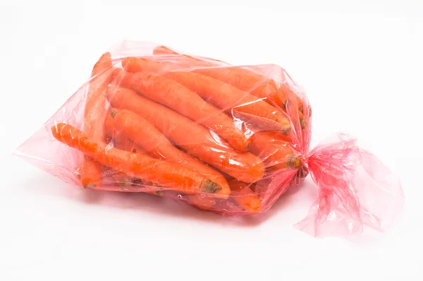 Karotte in Plastiktüte auf weißem Hintergrund — Stockfoto