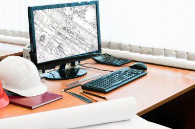 Working place with computer, hard hat and project drawings. Drawing in scre clipart