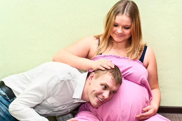 Pregnant woman with her husband hearing belly — Stock Photo, Image
