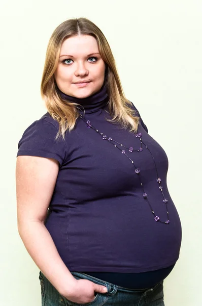 Zwangere jonge Kaukasische vrouw permanent. — Stockfoto