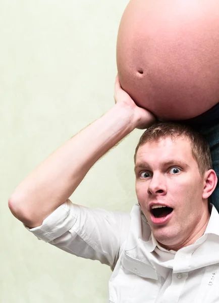 Pregnant woman with her amazed husband holding belly his hands. Caucasians, — Stock Photo, Image