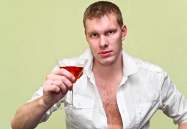 Handsome man sitting with glass of alcohol. Caucasian gay clipart