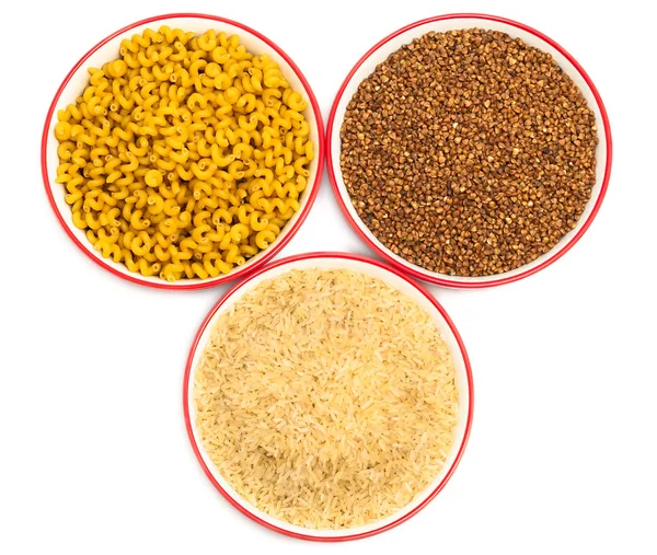 Drie plaat met droog voedselingrediënten als rijst, macaroni en boekweit — Stockfoto
