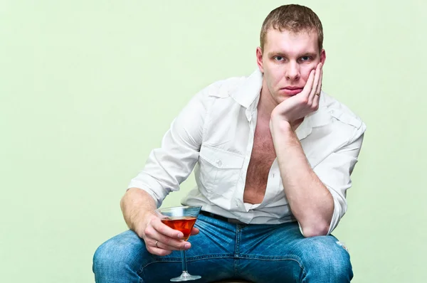 Красивий чоловік сидить зі склянкою алкоголю — стокове фото