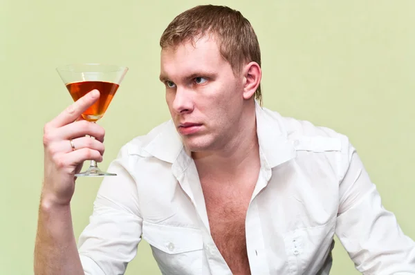 Красивий чоловік сидить зі склянкою алкоголю . — стокове фото