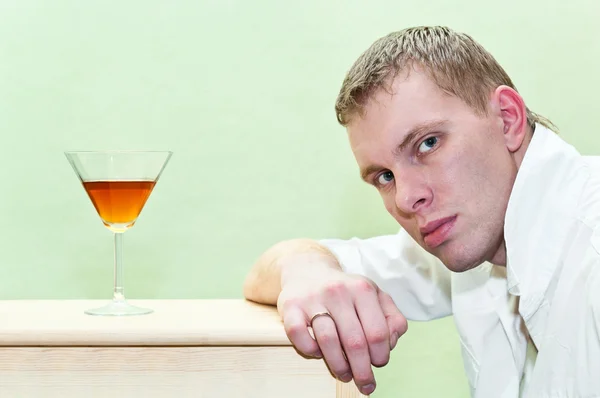 Красивый мужчина, сидящий со стаканом алкоголя. Кавказский гей — стоковое фото