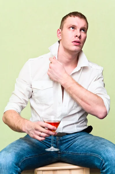 Bonito homem sentado com um copo de álcool. caucasiano gay — Fotografia de Stock
