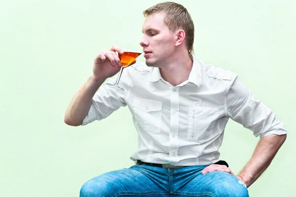 Bonito homem sentado com um copo de álcool — Fotografia de Stock