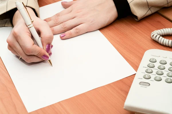 Manos de mujer escribiendo sobre papel blanco . — Foto de Stock
