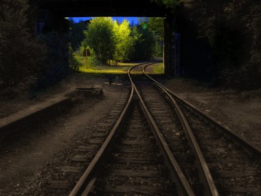 Railroad tracks which gradually disappear behind multicolored turn clipart