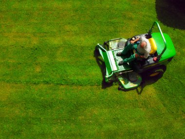 Top view of man on grass-cutter clipart