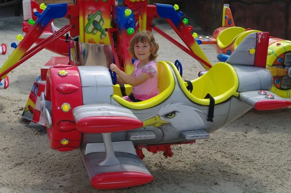 玩在飞机在游乐园里的旋转木马上的女孩 — 图库照片