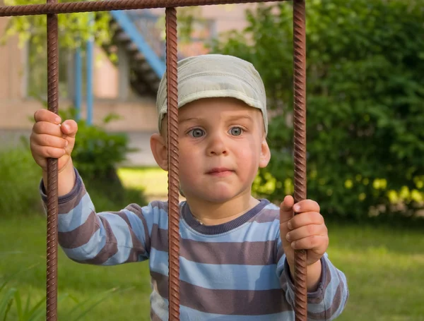 Мальчик за решеткой — стоковое фото