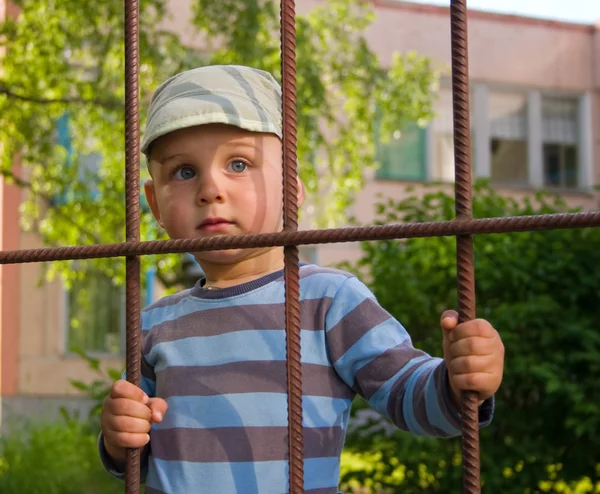 Der Junge hinter einem Gitter — Stockfoto