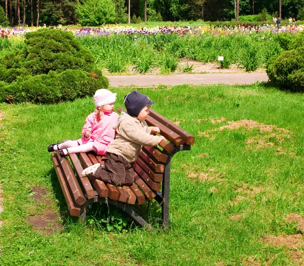 男の子と女の子のベンチに公園で — ストック写真