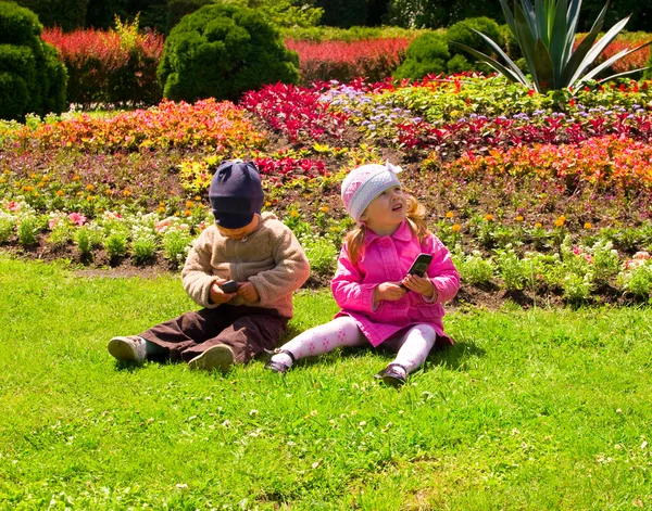 Pojke Och Flicka Som Leker Parken Med Mobiltelefoner — Stockfoto