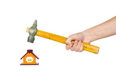 Hand with a hammer destroys small house clipart