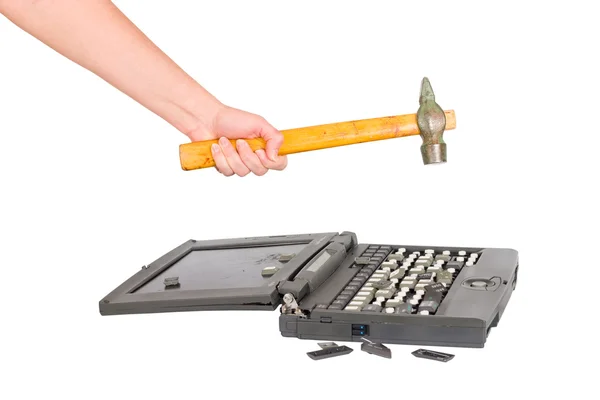 Hånd med en hammer ødelægger laptop - Stock-foto